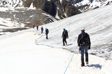 Rope team mountaineering with crampons on glacier Taschachferner and mountain snow panorama with blue sky in Tyrol Alps, Austria