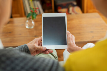 リビングでタブレット端末を使う老夫婦