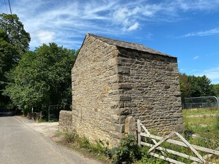 Small stone building, next to a gate, leading into a field on, Carla Beck Lane, on a sunny day in, Carleton, Skipton, UK