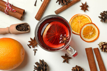 Cup of mulled wine and ingredients on white background