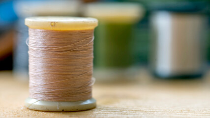 Reels or spools of multicolored sewing threads. Threads of all colors. Shallow depth of field....