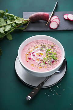Vegan red radish cream soup with popped amaranth, chia seeds, cress and garlic oil