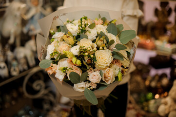 elegant beautiful bouquet of roses decorated with eucalyptus branches in female hands