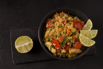 Asian khao pad kung fried rice with vegetables, meat, egg, fresh cucumbers and tomatoes
