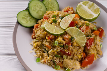 Asian khao pad kung fried rice with vegetables, meat, egg, fresh cucumbers and tomatoes