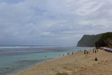 Beach with a cloudy atmosphere, which is crowded with tourists