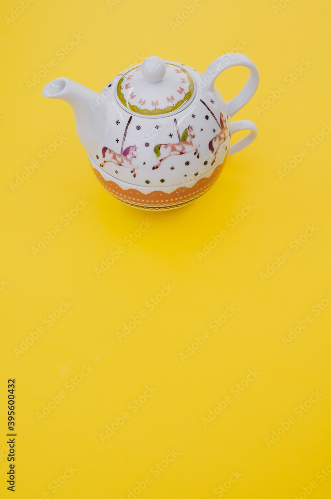 Sticker Vertical shot of decorative teapot isolated on yellow background