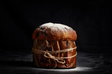 Easter bread. Christmas panettone. With icing sugar on top. On dark background