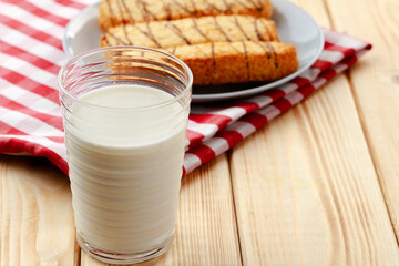 Oat cookies and glass of milk on wooden table
