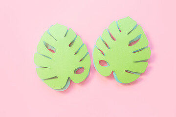 Paper monstera leaves on a pink background. Creative paper art. Background bright summer image.