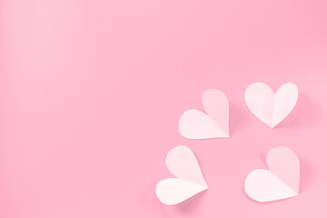 Pink paper hearts on a pink background. Concept of romance, love, valentine's day. Minimalism, copy space, paper art.