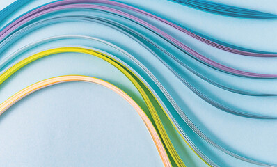 top view of colorful wavy paper stripes for kwilling on blue background