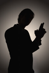 Silhouetted Man Making Gun Shaped Gesture