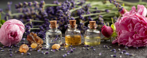 Panoramic header of essential oil bottles, lavender, frankincense and roses - obrazy, fototapety, plakaty