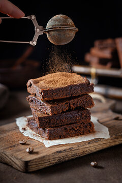 Brownies being dusted with cocoa