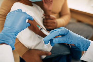 Close-up of African American child receiving a vaccine at pediatrician's office.
