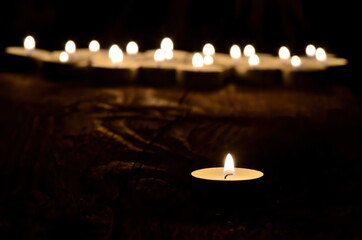 Many small christmas candles burning at dark. Shallow depth of field, selective focus