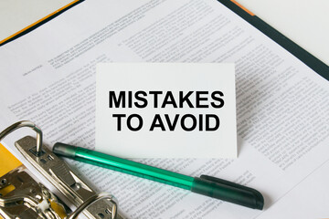 Text Mistakes To Avoid on a white card that is in a folder with documents and a green pen