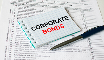 Notepad with text Corporate Bonds lying on financial tables with a pen