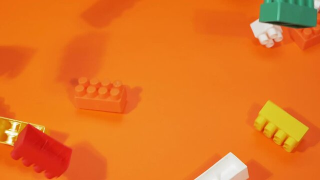 Blocks fall from the top to the orange background. Slow motion.
