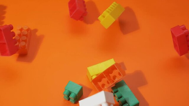 Blocks fall from the top to the orange background. Slow motion.