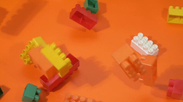 Blocks fall from the top to the orange background. Slow motion.