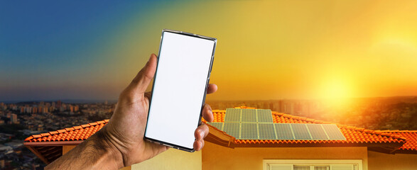 Male hands holding a mobile with solar energy photovoltaic panel at background. Space for text