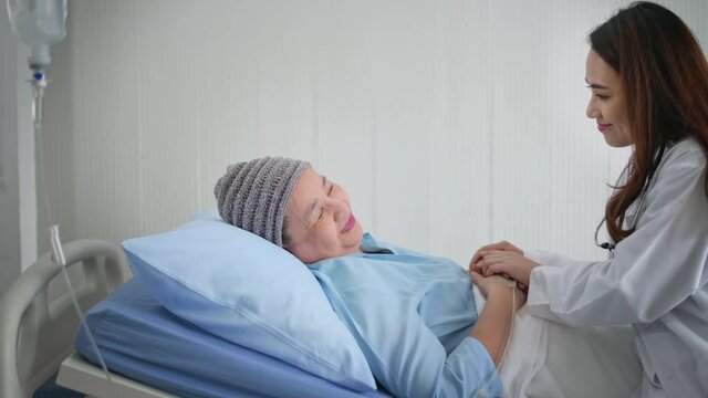 Cancer patient woman wearing head scarf after chemotherapy consulting and visiting doctor in hospital.