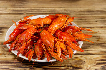 Boiled crayfish in plate on wooden table