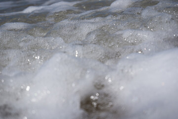 a foam wave of the north sea breaking on the beach
