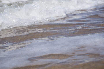 a foam wave of the north sea breaking on the beach
