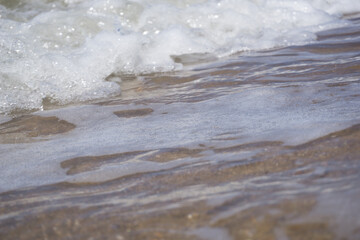 Fototapeta na wymiar a foam wave of the north sea breaking on the beach 