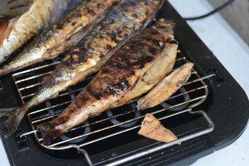 Barbecue with fish. Grilled mackerel fish. Fatty, oily fish is an excellent and healthy source of DHA and EPA, which are two key types of omega-3 acid.
