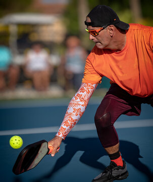 Digging deep for a low pickleball return by a professional pickleball player