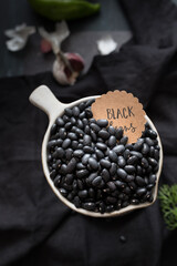 Closeup view of a white bowl full of black beans.