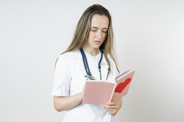 Medicine and health concept. Young female doctor writes in a notebook.