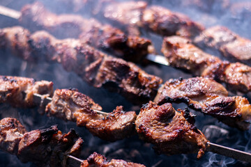 Shish kebab BBQ meat. Raw meat cubes on metal skewer over the coals. Cooking meat kebabs on grill.