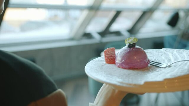 Slow motion of waitress carrying plate with delicious dessert then putting it on table in modern restaurant . Tasty sweet food and eating out concept.