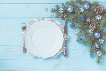 Christmas light blue table setting, menu concept. Pine tree branches, blue silver baubles, stars, hearts, cones, snowflakes. Christmas festive decoration, corner set. Flat lay, top view, copy space.