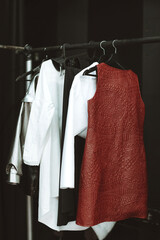 Bunch of materials with different patterns hanging in bunch, clearly visible texture. Stylish clothing. Vertical shot