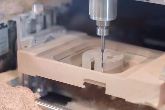 CNC engraving, woodworking, carving, industrial, manufacturing concept. Automated milling machine cutting wooden workpiece from wood pulp, making 3d model at technology exhibition, factory - close up.