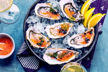 Tasty oysters on ice with lemon.
Refined with herbs and salmon caviar.