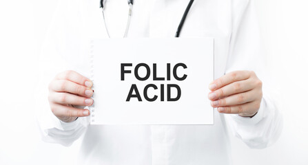 Doctor holding a card with text Folic Acid, medical concept