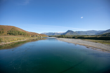 landscape with mountains, forest and a river in front. beautiful scenery