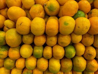 Many fresh mandarin fruits. mandarins on the market. stacked tangerines