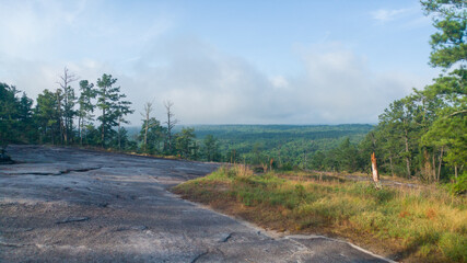 View from a mountain type with a large rolling cloud and blue sky with sparse vegetation