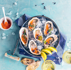 Tasty oysters on ice with lemon. Refined with herbs and salmon caviar. © karepa