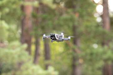 Drone with professional cinema camera flying  in the forests