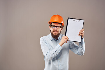 A man in a shirt with an orange hard hat engineer work documents rendering services