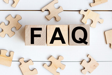 FAQ, text on wooden cubes on a white background near wooden puzzles